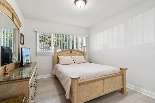 a bedroom with a bed and a flat tv screen on dresser