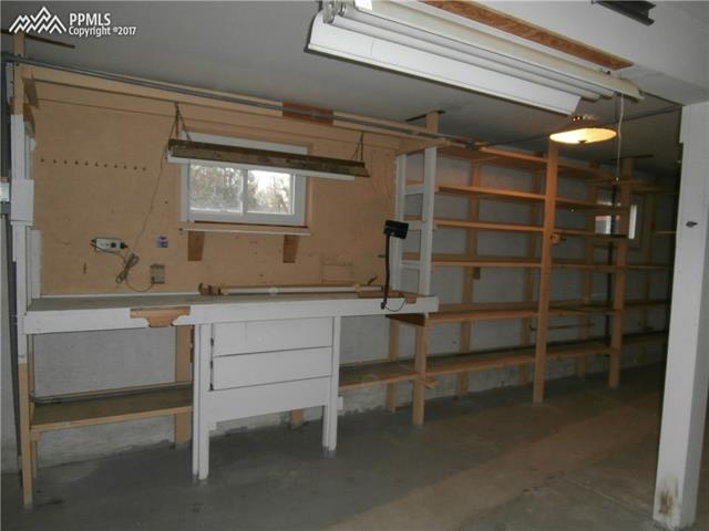 1642 Fuller Road Colorado Springs, CO 80920 - Photo 18 of 22 Oversized attached garage is complete with this sweet workbench and storage