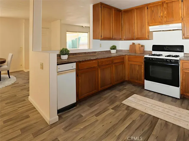 a kitchen with granite countertop a stove a sink and a refrigerator