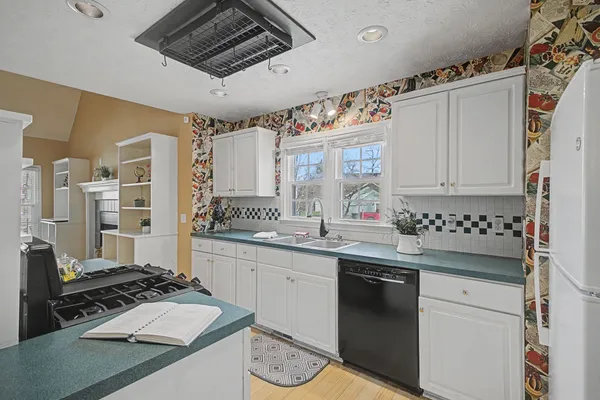 a kitchen with granite countertop a sink stove and cabinets