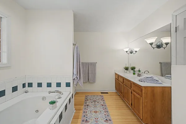 a bathroom with a sink a bathtub and a mirror