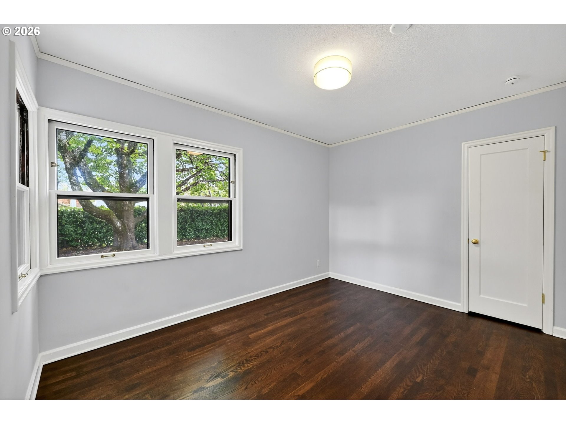 8035 Southwest 8th Avenue Portland, OR 97219 - Photo 22 of 42 a view of an empty room with wooden floor and a window