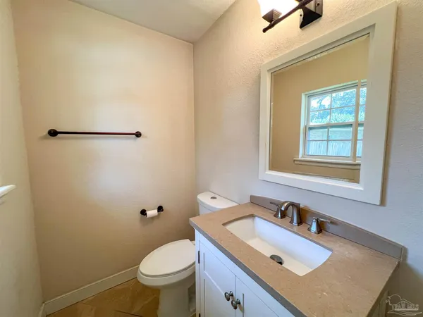 a bathroom with a sink toilet and window