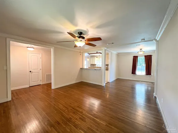 a view of a livingroom with a ceiling fan window and wooden floor