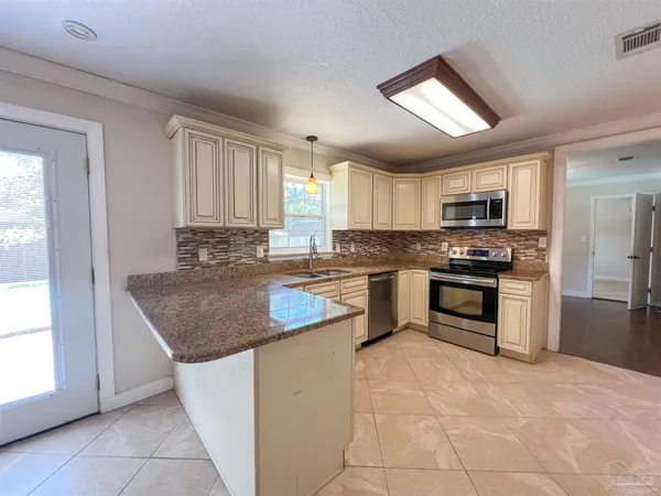 a kitchen with stainless steel appliances granite countertop a stove sink and microwave