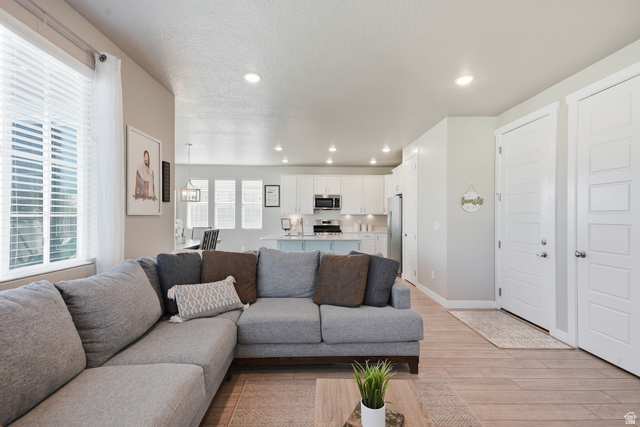 3244 West 1670th Street North Provo, UT 84601 - Photo 22 of 56 Open-concept living space featuring wood-finish flooring and recessed lighting
