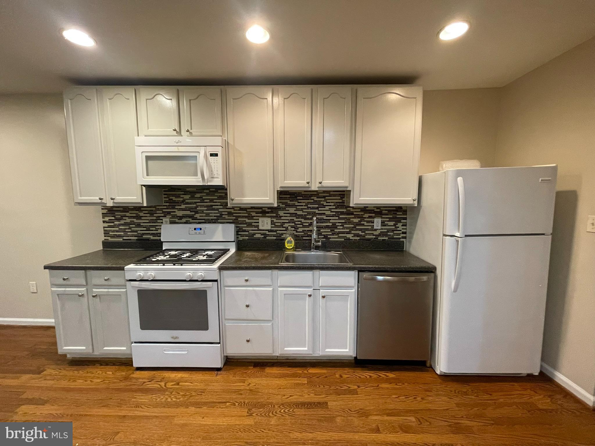 1913 Rosedale Street Northeast, Unit 1 Washington, DC 20002 - Photo 18 of 31 a kitchen with stainless steel appliances granite countertop a refrigerator stove a sink and a microwave