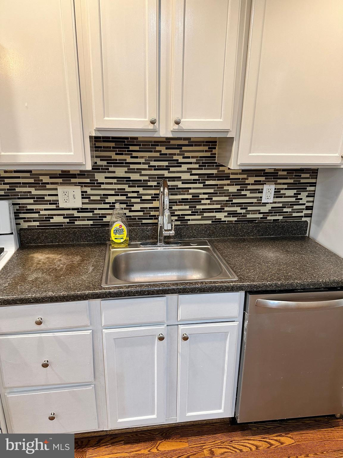 1913 Rosedale Street Northeast, Unit 1 Washington, DC 20002 - Photo 20 of 31 a kitchen with granite countertop white cabinets and white appliances