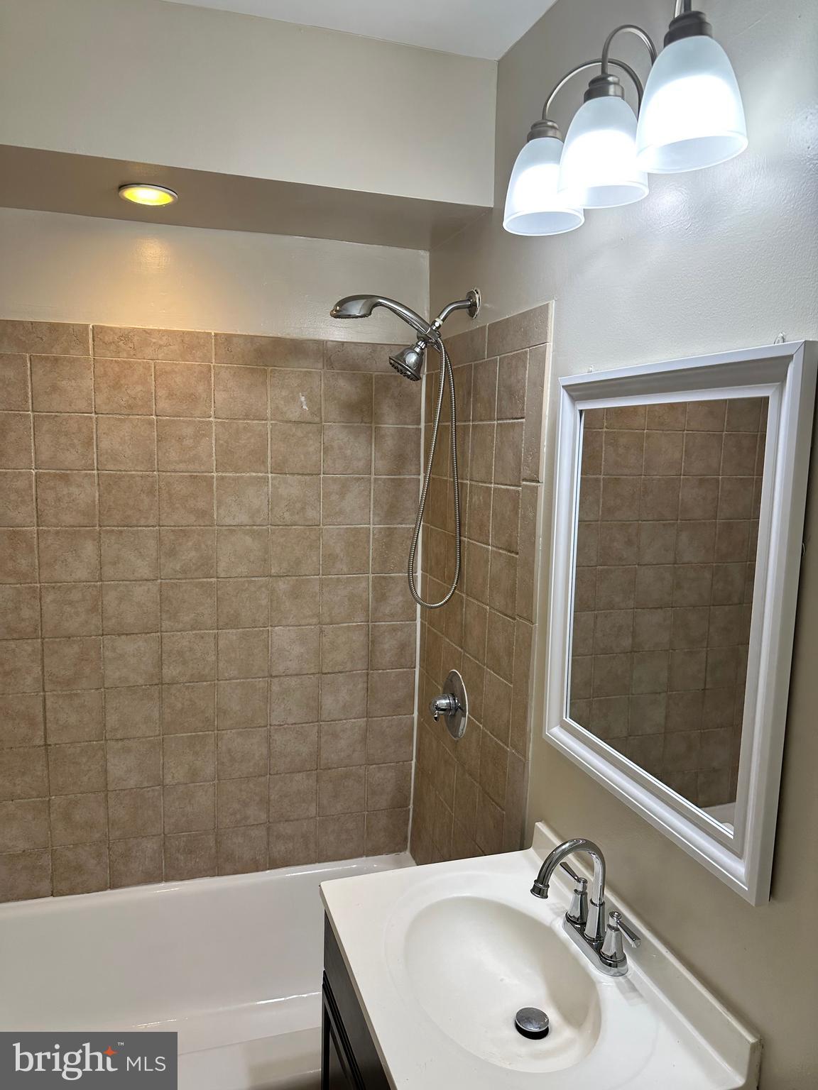 1913 Rosedale Street Northeast, Unit 1 Washington, DC 20002 - Photo 24 of 31 a bathroom with a sink a shower and a mirror