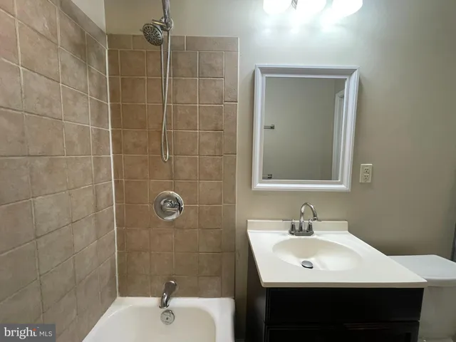 a bathroom with a sink shower and a mirror