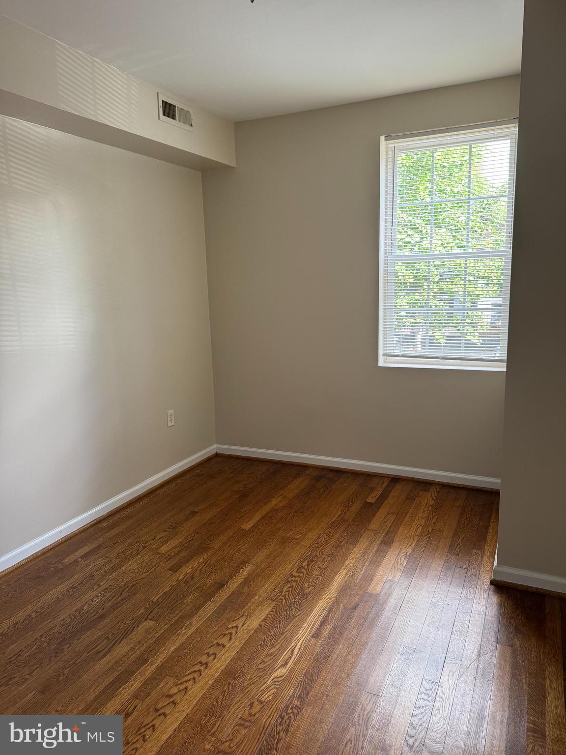 1913 Rosedale Street Northeast, Unit 1 Washington, DC 20002 - Photo 9 of 31 a view of an empty room with wooden floor and a window