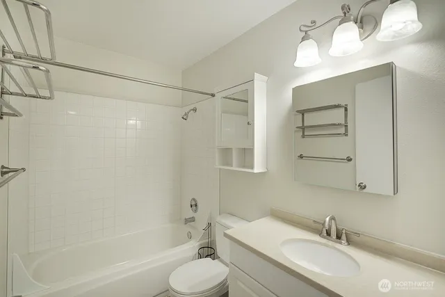 a bathroom with a granite countertop sink a toilet and shower