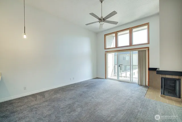 an empty room with windows and fireplace