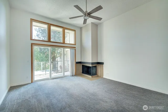 an empty room with windows and fireplace