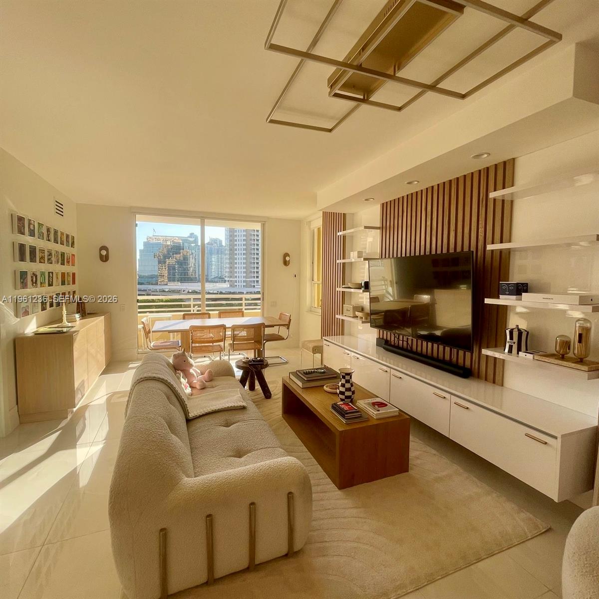 888 Brickell Key Drive, Unit 802 Miami, FL 33131 - Photo 2 of 16 a living room with furniture fireplace and a flat screen tv