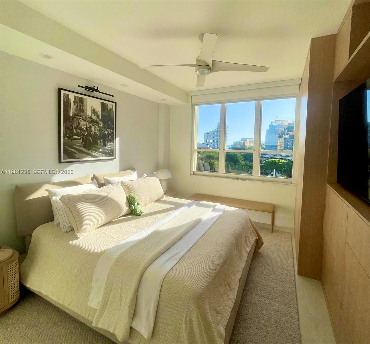 888 Brickell Key Drive, Unit 802 Miami, FL 33131 - Photo 9 of 16 a bedroom with a bed and a flat screen tv