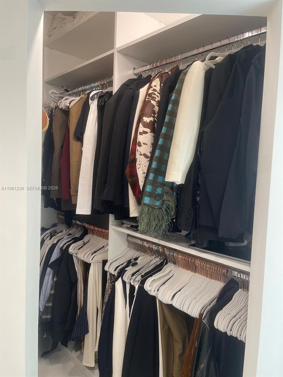888 Brickell Key Drive, Unit 802 Miami, FL 33131 - Photo 10 of 16 a view of walk in closet with clothes and shoes