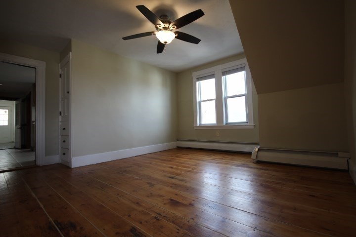 74 Green Hill Parkway Worcester, MA 01605 - Photo 17 of 42 an empty room with wooden floor chandelier fan and windows