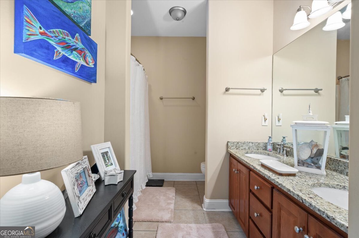7272 Shellman Bluff Road Northeast, Unit 21 Townsend, GA 31331 - Photo 23 of 34 a bathroom with a granite countertop sink and a mirror