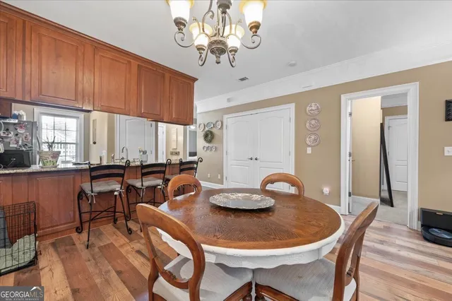 a view of a dining room with furniture a chandelier and wooden floor