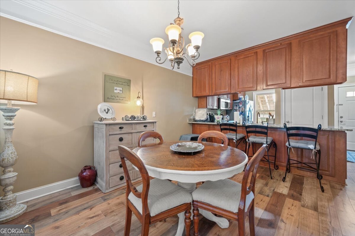 7272 Shellman Bluff Road Northeast, Unit 21 Townsend, GA 31331 - Photo 9 of 34 a view of a dining room with furniture a chandelier and wooden floor