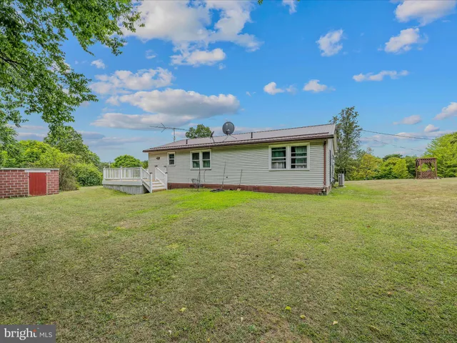 a backyard of a house with trees and wooden fence
