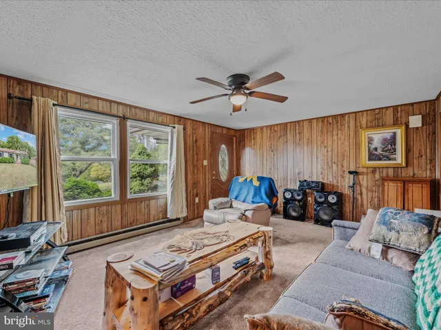 a living room with furniture a flat screen tv and a large window