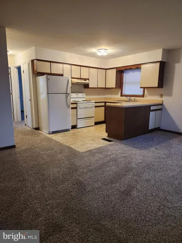 a living room with lots of furniture and kitchen view