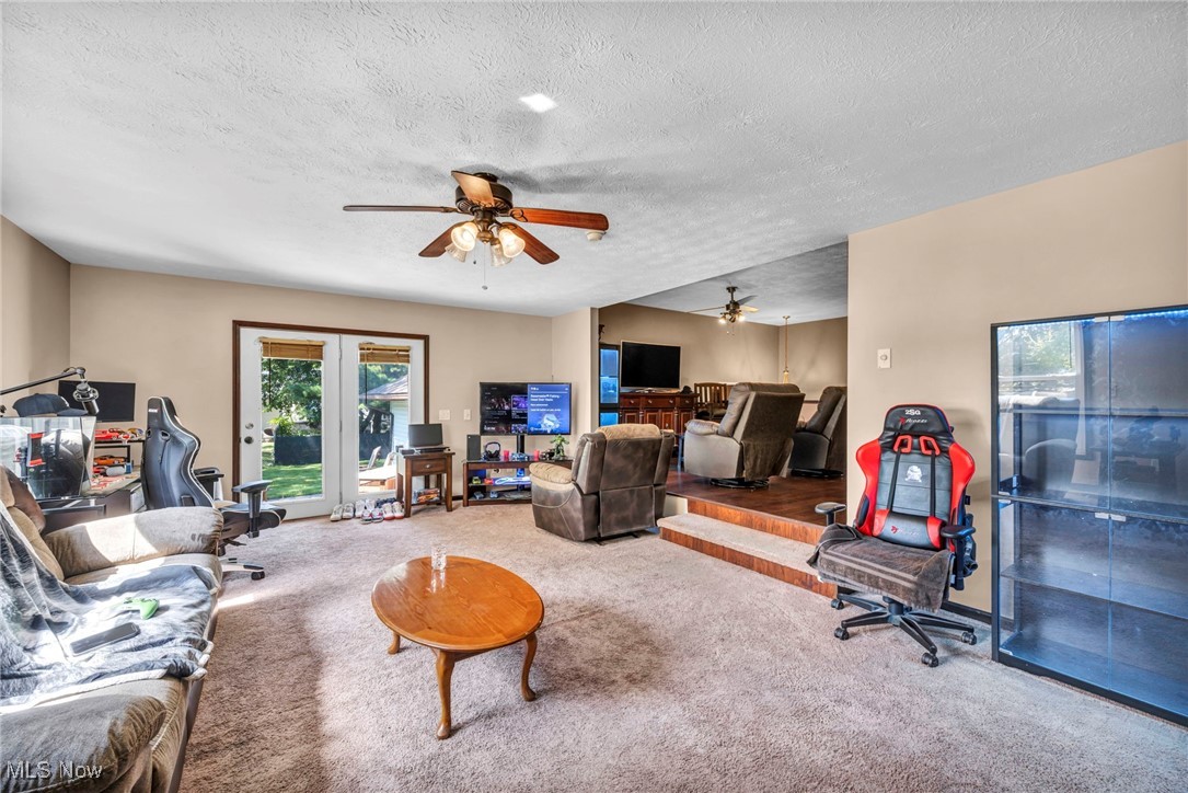 5704 McCartney Road Sandusky, OH 44870 - Photo 16 of 50 Carpeted living area with a ceiling fan, a textured ceiling, and an office area
