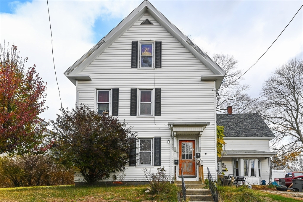 80-82 Maple Street Gardner, MA 01440 - Photo 4 of 4 a view of a white house with large windows and a small yard