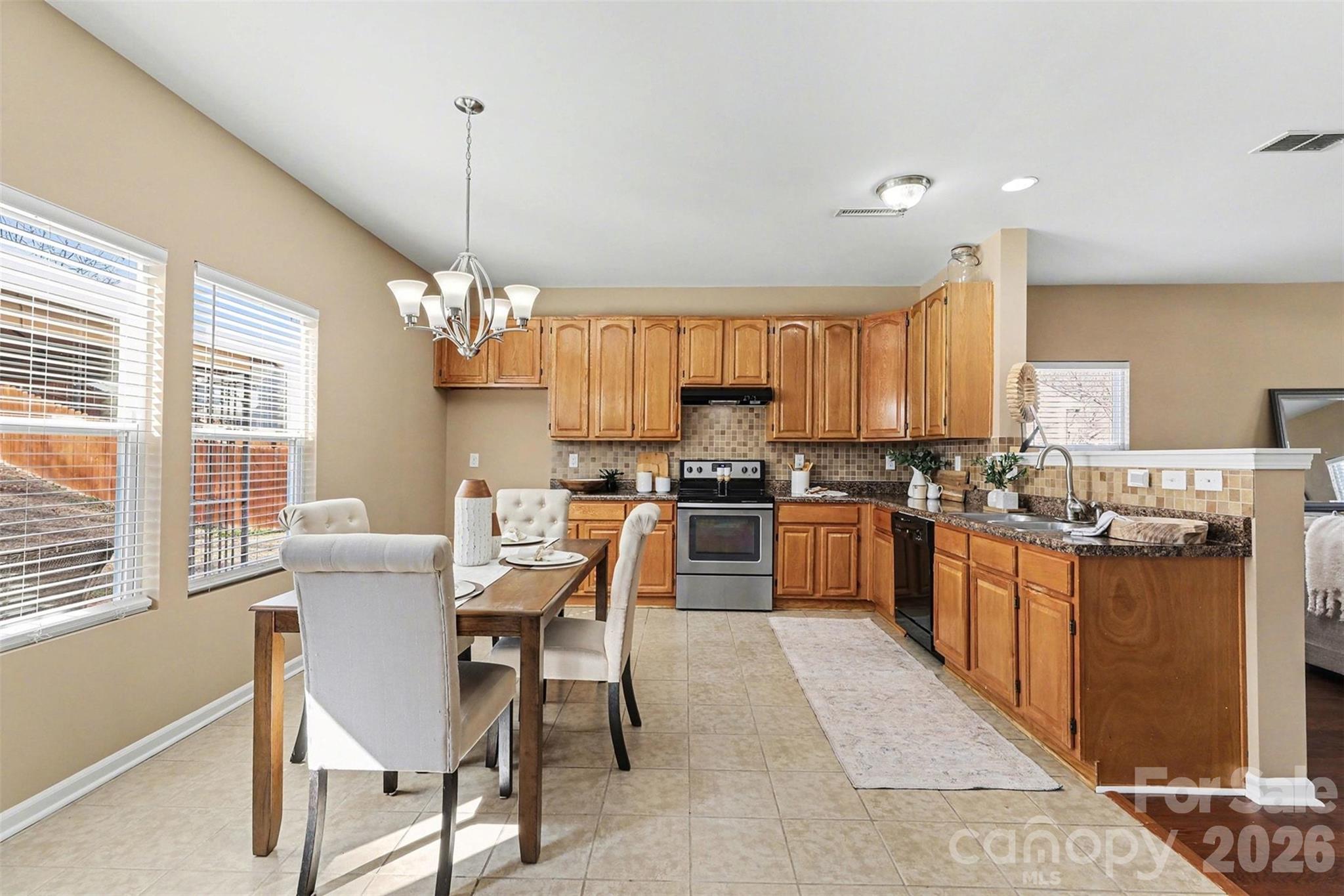 1806 Tradd Avenue Clover, SC 29710 - Photo 8 of 30 a kitchen with stainless steel appliances granite countertop a stove top oven a sink dishwasher a dining table and chairs with wooden floor