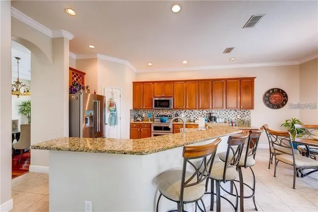 a kitchen with stainless steel appliances granite countertop a kitchen island a stove and a refrigerator