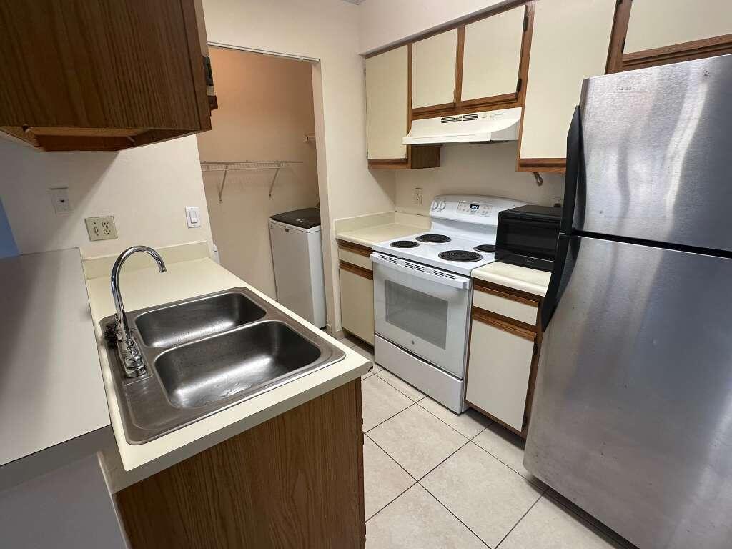 1239 Southwest 46th Avenue, Unit 906 Pompano Beach, FL 33069 - Photo 11 of 23 a kitchen with stainless steel appliances a refrigerator sink and stove