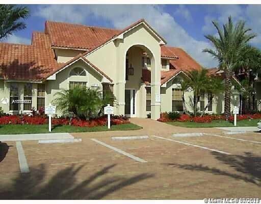 1239 Southwest 46th Avenue, Unit 906 Pompano Beach, FL 33069 - Photo 20 of 23 a view of a white house with a swimming pool and a lawn chairs next to a yard