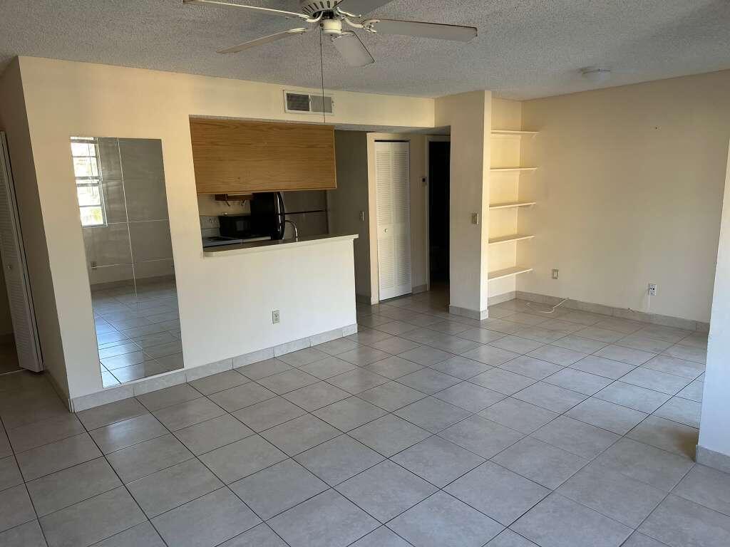1239 Southwest 46th Avenue, Unit 906 Pompano Beach, FL 33069 - Photo 4 of 23 wooden floor in an empty room with a bathroom