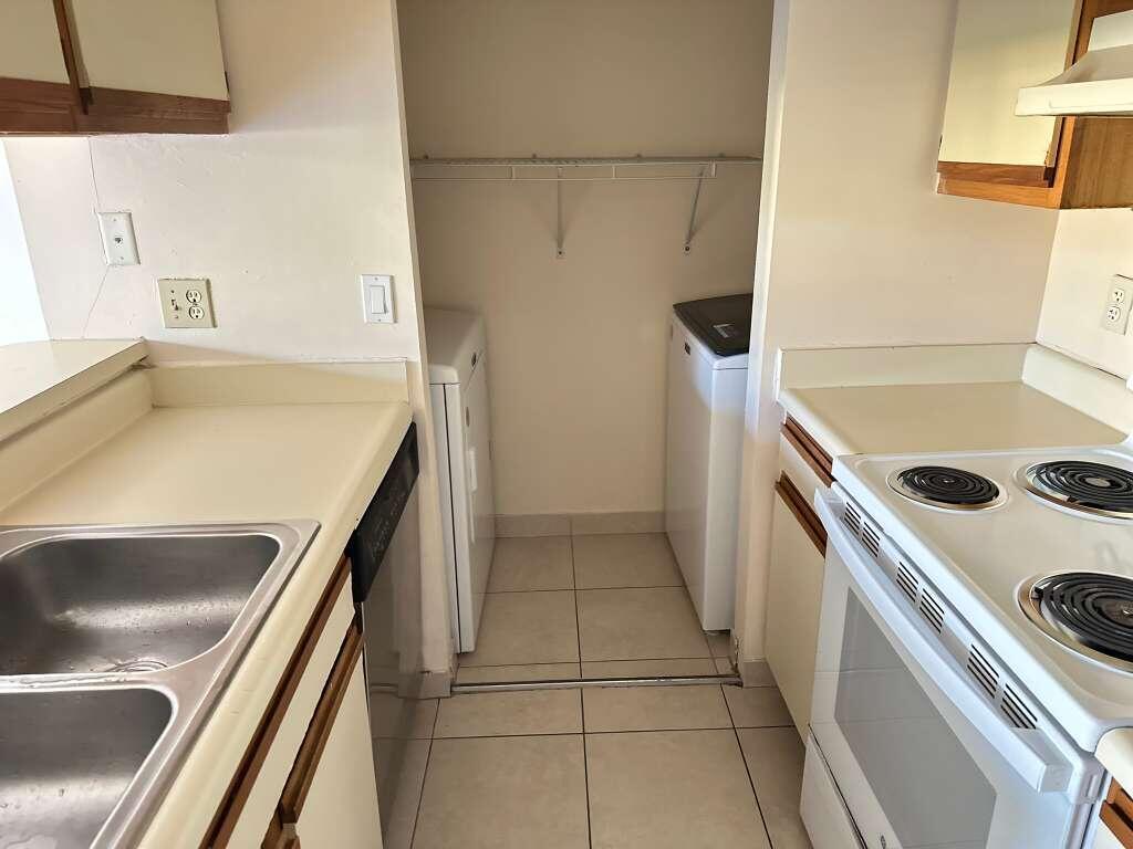 1239 Southwest 46th Avenue, Unit 906 Pompano Beach, FL 33069 - Photo 10 of 23 a kitchen with a sink a stove and a refrigerator
