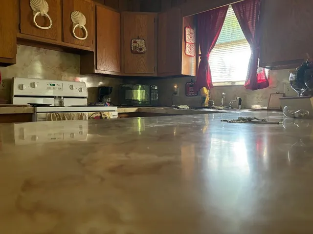 a kitchen with stainless steel appliances granite countertop a stove a sink and a microwave