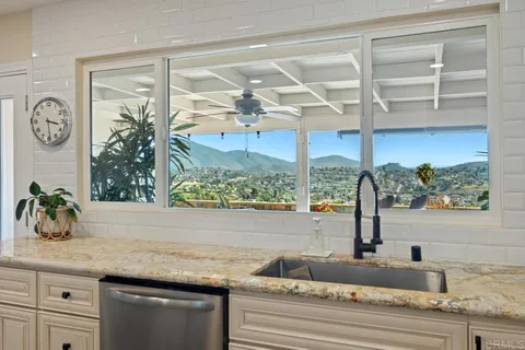 a bedroom with a bed a chandelier and large window