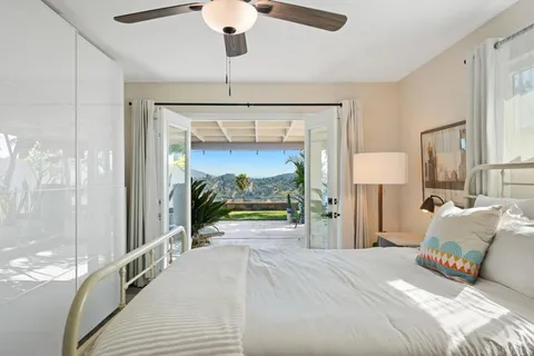 a bedroom with a large bed and a chandelier