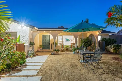 a backyard of a house with table and chairs