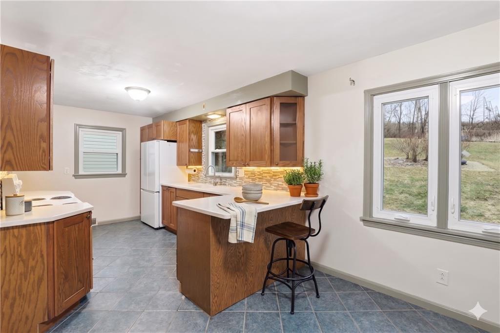 123 Wampum Road Wampum, PA 16157 - Photo 8 of 33 a kitchen with a stove a refrigerator a sink dishwasher with a dining table and chairs