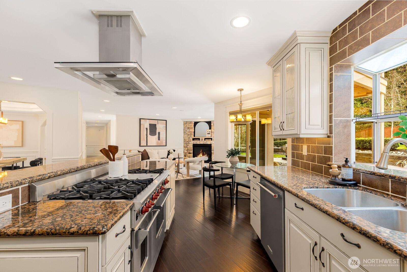 4826 196th Street Southeast Bothell, WA 98012 - Photo 11 of 40 a kitchen with stove a sink dishwasher and a dining table with wooden floor