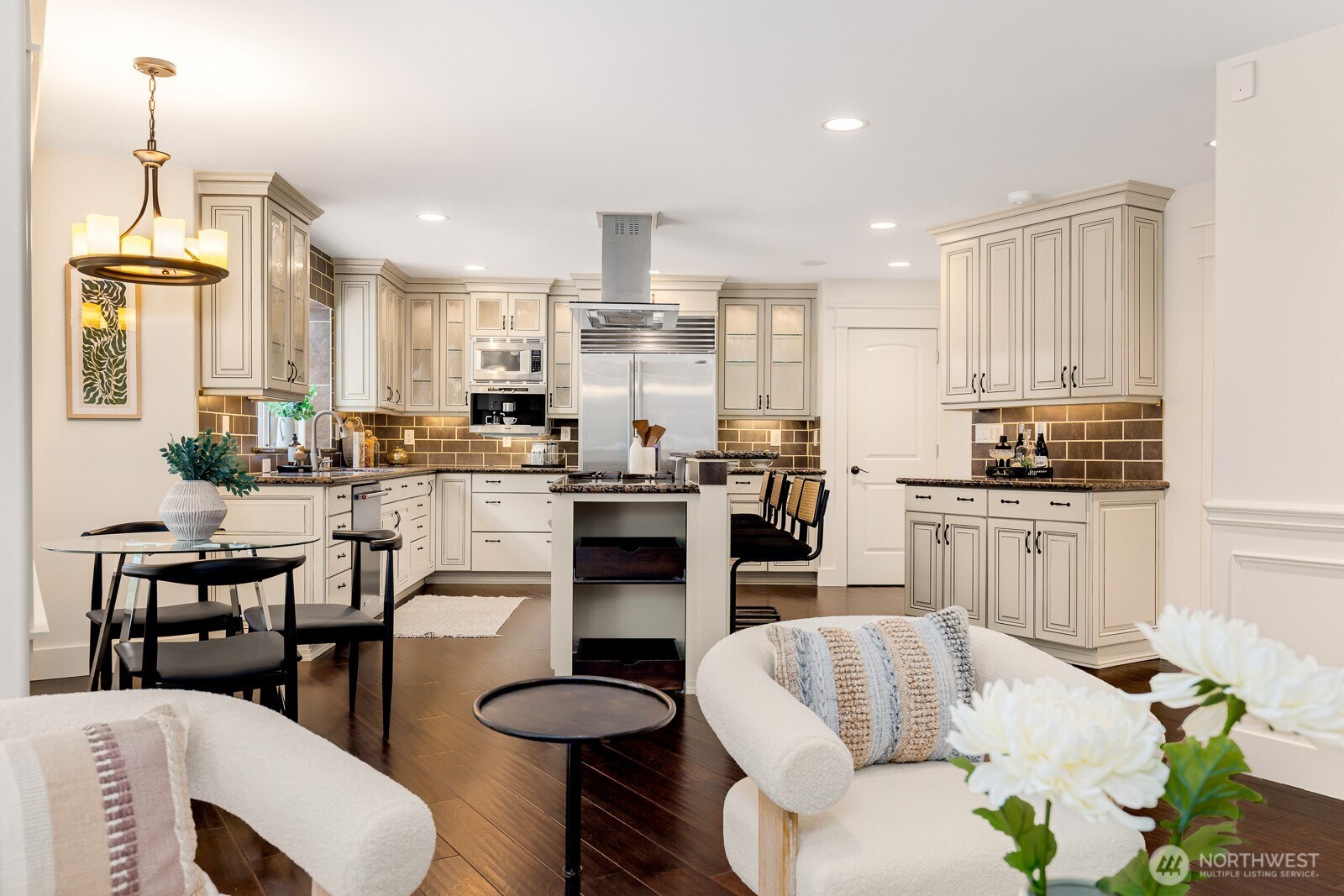 4826 196th Street Southeast Bothell, WA 98012 - Photo 9 of 40 a kitchen with stainless steel appliances kitchen island granite countertop a refrigerator a stove a sink a dining table and chairs with wooden floor