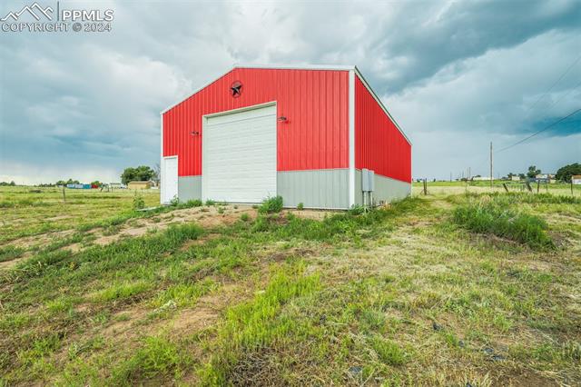 12550 Smith Road Peyton, CO 80831 - Photo 7 of 35 View of outbuilding with a rural view and a garage