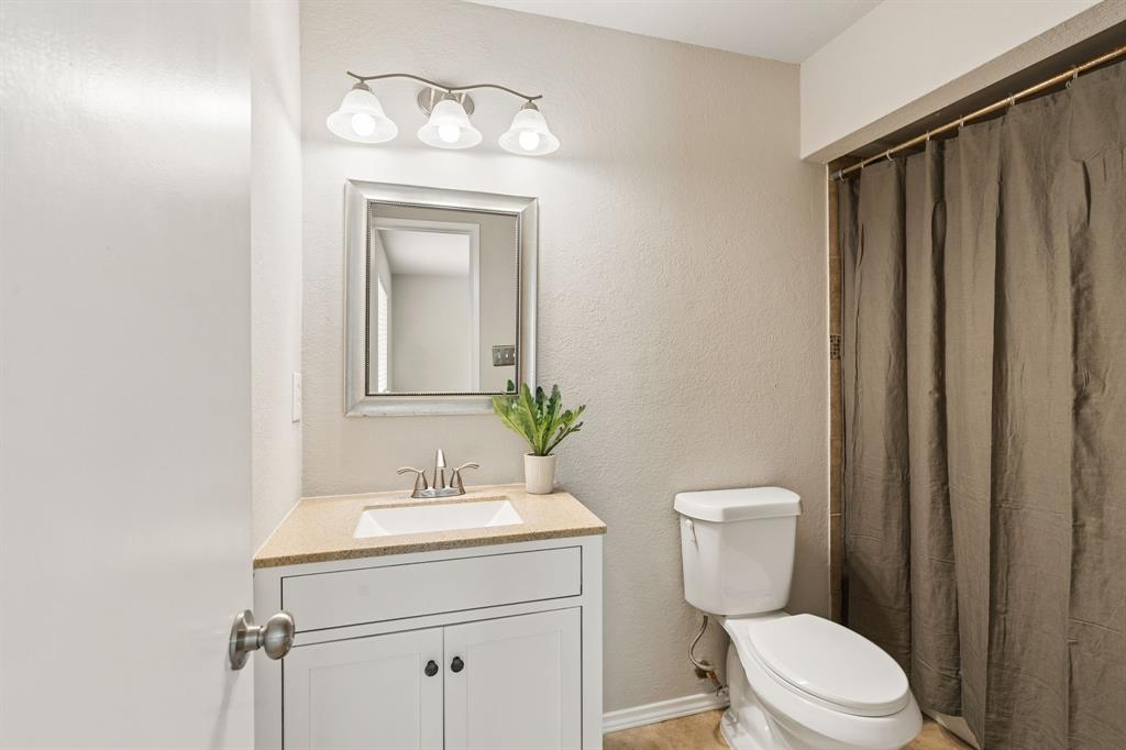5620 Perrin Street The Colony, TX 75056 - Photo 15 of 31 a bathroom with a toilet a sink and a mirror