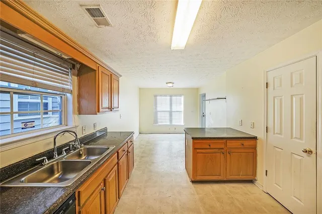 a kitchen with a sink stove top oven and cabinets
