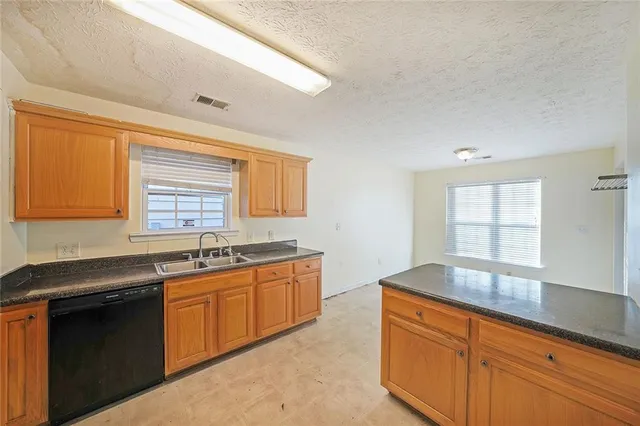 a kitchen with stainless steel appliances granite countertop a sink stove and cabinets