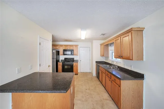 a kitchen with stainless steel appliances granite countertop a stove and a sink