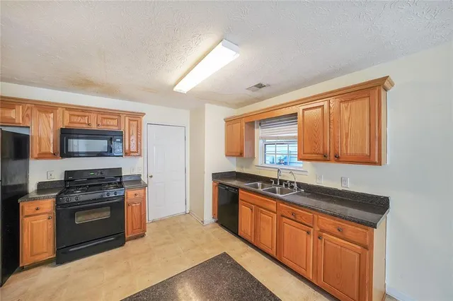 a kitchen with stainless steel appliances granite countertop a stove sink and microwave