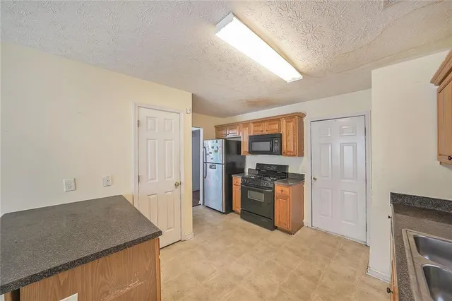 a kitchen with stainless steel appliances granite countertop a refrigerator stove and oven